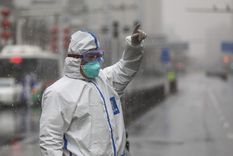 Una persona con traje de protección frente a un hospital en la ciudad china de Wuhan, Hubei, 15 de febrero de 2020.