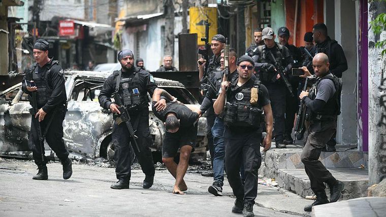 Policías escoltan a un sospechoso detenido durante la Operación Contención, en la favela de Vila Cruzeiro, en el complejo de Penha, en Río de Janeiro, el 28 de octubre de 2025. Policías escoltan a un sospechoso detenido durante la Operación Contención, en la favela de Vila Cruzeiro, en el complejo de Penha, en Río de Janeiro, el 28 de octubre de 2025.