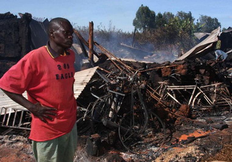 Un hombre mira los restos de una iglesia en Kenia, en la que fueron quemadas unas 50 personas. Foto: NA