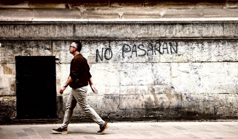 Un hombre pasa junto a un graffiti No pasarán en París, Francia, el 1 de julio de 2024. Foto: Efe.