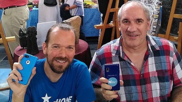 Urs Lesse (izquierda) ayuda a las personas a reparar sus teléfonos. Foto: URS LESSE