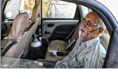 Sushil Kumar Srivastava fue fotografiado en su auto, conectado a una botella de oxígeno en la ciudad de Lucknow. Foto: SUMIT KUMAR