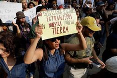 De México a Barcelona, algunos lugareños no están de acuerdo con la gran afluencia de turistas. (Manifestantes en Ciudad de México).