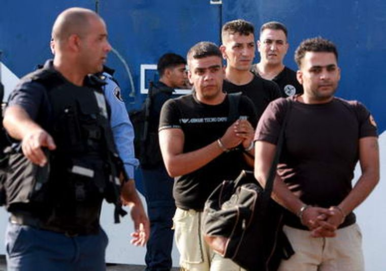 Guardias israelíes escoltan a unos prisioneros que fueron liberados. Foto: EFE