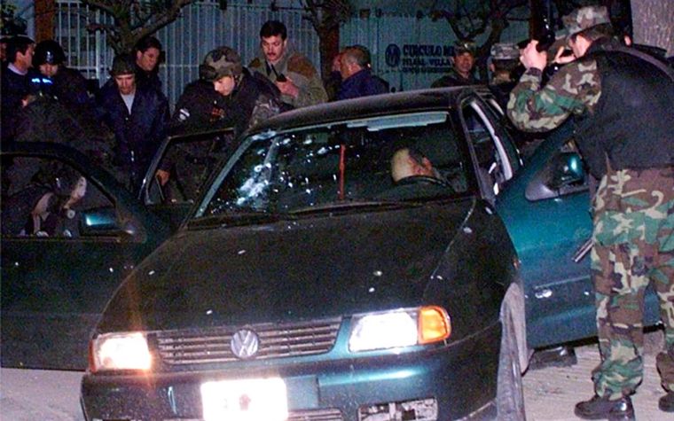 El vehículo atacado por los policías, aún con el cuerpo de Carlos Cháves, gerente de la sucursal en el automóvil. Foto: NA