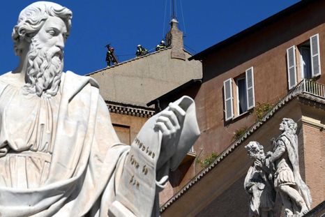 Obreros trabajan instalando la chimenea en el techo de la Capilla Sixtina. Foto: Efe.