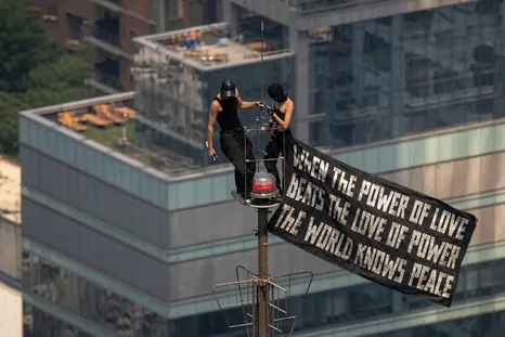 Esta pareja de rusos colgó en el Empire State una bandera que decía: Cuando el poder del amor venza al amor por el poder, el mundo conocerá la paz.