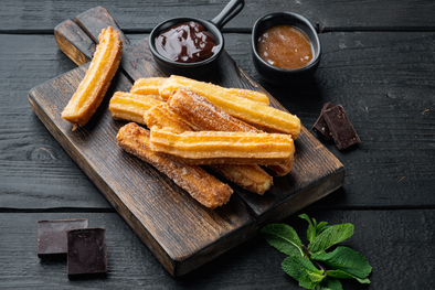 MDZol | La forma alargada y estriada de los churros se logra usando una manga pastelera con boquilla estrellada, lo que también ayuda a que queden más crujientes.