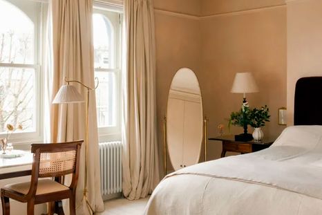 La diseñadora de interiores Jessica Summer creó un color de pintura personalizado para este sereno dormitorio, optando por un tono entre rosa y beige que adorna delicadamente las paredes de la habitación. La diseñadora de interiores Jessica Summer creó un color de pintura personalizado para este sereno dormitorio, optando por un tono entre rosa y beige que adorna delicadamente las paredes de la habitación.