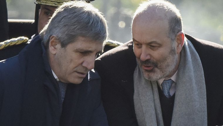 El presidente del BCRA, Santiago Bausilli y el ministro de Economía, Luis Caputo, intercambian bonos. Foto: EFE