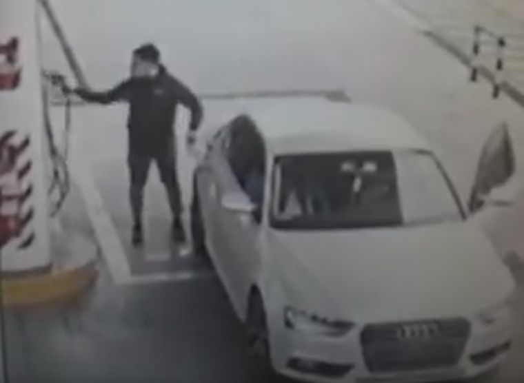 El momento en que el conductor del Audi saca la manguera de su auto para irse sin pagar