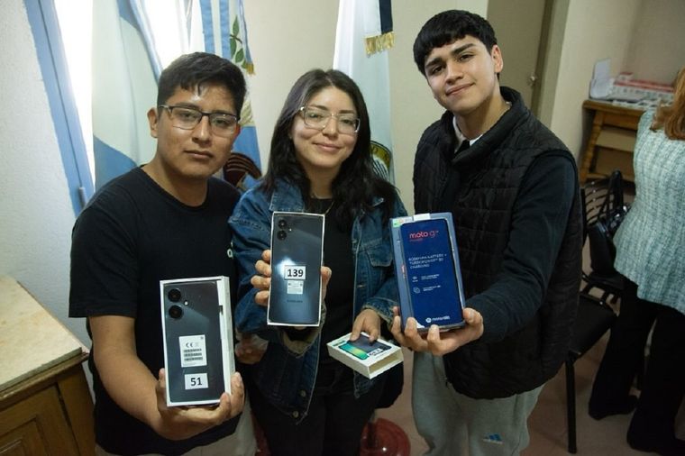 Estudiantes de la UNCuyo mostrando los celulares recibidos.