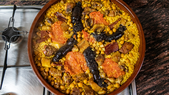 La receta de arroz al horno valenciano tiene su origen en el aprovechamiento del caldo sobrante del cocido, convirtiéndose en una receta ingeniosa que transformaba restos en un plato principal lleno de sabor.