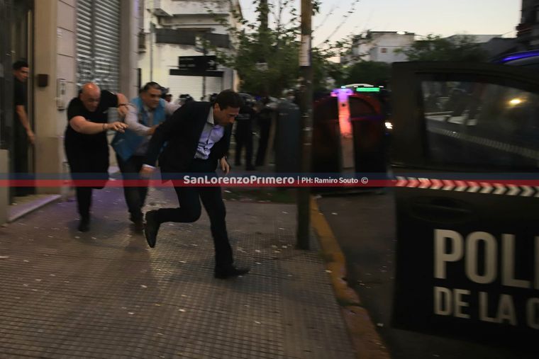 Marcelo Moretti, corriendo hacia un patrullero para escapar de la sede de San Lorenzo en medio de los incidentes con hinchas y la intervención policial. Foto: San Lorenzo Primero. 
