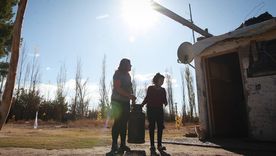 Antonela junto a una de sus hijas llevando una garrafa.