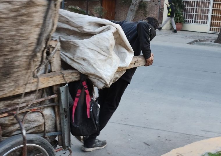 Alexis tracciona el carro donde guarda el material reciclable que recolecta.