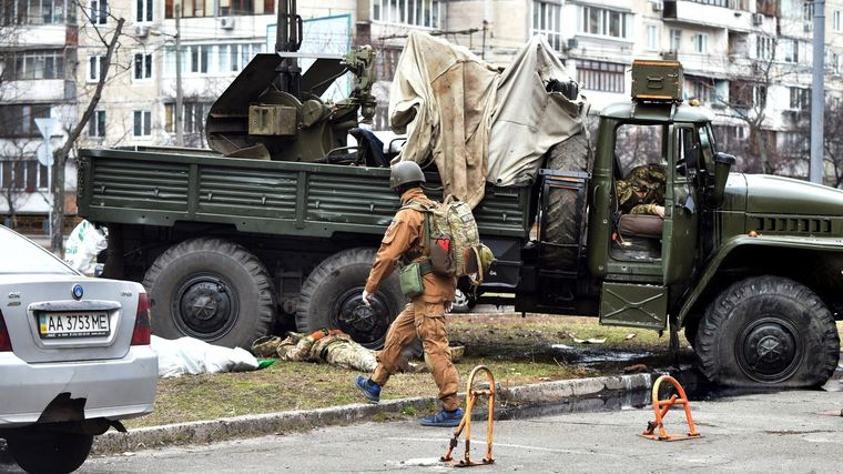 Un médico militar de Ucrania observa cuerpos de soldados rusos. Foto: Afp.