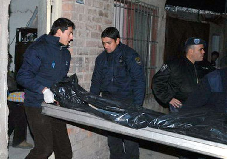 Momento en que sacan los cuerpos de la vivienda. Foto: Gonzalo Bravo