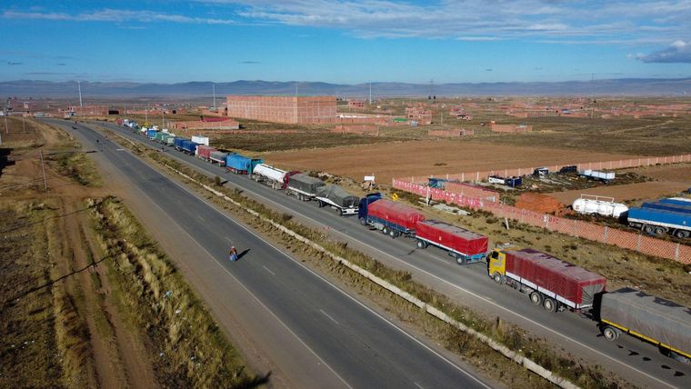 Una hilera de camiones esperan en la ruta para poder pasar en medio de los cortes de carreteras.