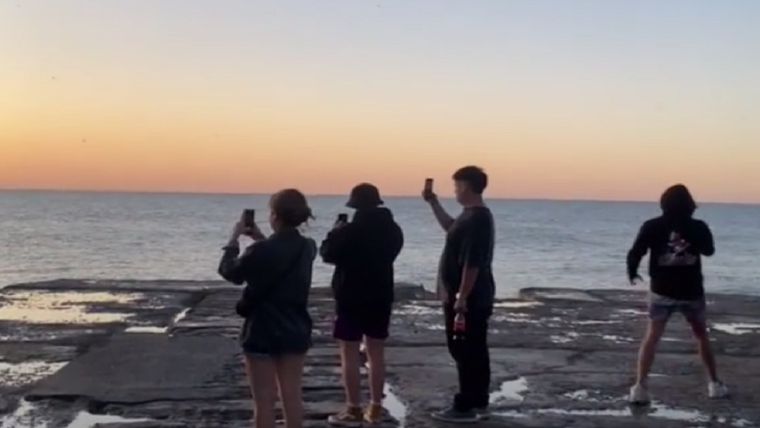 Los jóvenes admirando el amanecer en la costa marplatense Foto: Captura de video