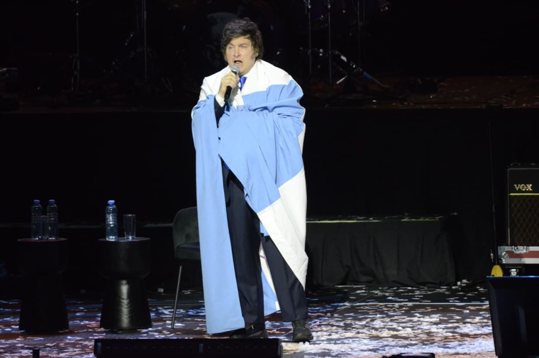Javier Milei envuelto en una bandera argentina durante el show. 