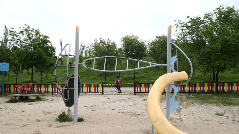 Mujer pasea con dos niños en el primer día en el que pueden salir de sus casas, Madrid, España, 26 de abril de 2020.