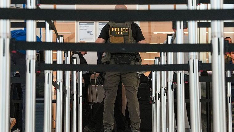 Un agente de ICE ayuda a los agentes de la TSA en el control de seguridad del Aeropuerto LaGuardia  en Nueva York.