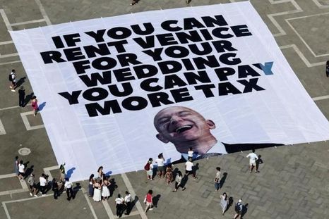 "Si puedes alquilar Venecia para tu boda, puedes pagar más impuestos", dice una pancarta contra Jeff Bezos. "Si puedes alquilar Venecia para tu boda, puedes pagar más impuestos", dice una pancarta contra Jeff Bezos.