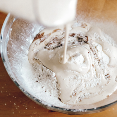 Precalentá el horno a 180 °C. En un bol, mezclá los huevos, el yogur griego, la leche y el eritritol o edulcorante. Agregá la harina integral, el cacao amargo y el polvo de hornear, integrando hasta obtener una masa homogénea.