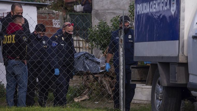 El momento en que los efectivos retiraron los cuerpos. Foto: Télam