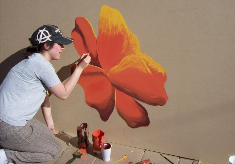 Alumna pintando el mural del colegio Niño Jesús.