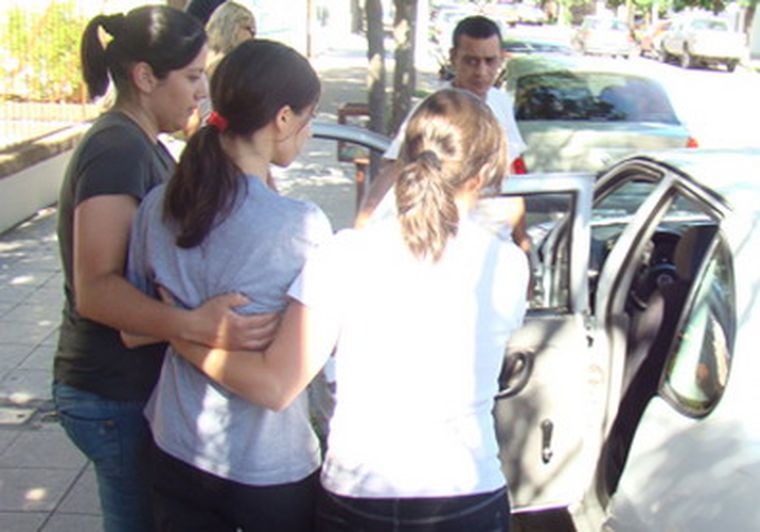 Momento en que la joven es conducida por dos mujeres policías fuera de la institución. Foto: Gentileza Diario Textual