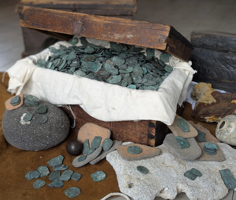 Cofre repleto de monedas y restos arqueológicos hallados en el área conocida como la “Costa del Tesoro” de Florida, vinculados a los naufragios de la flota española de 1715.