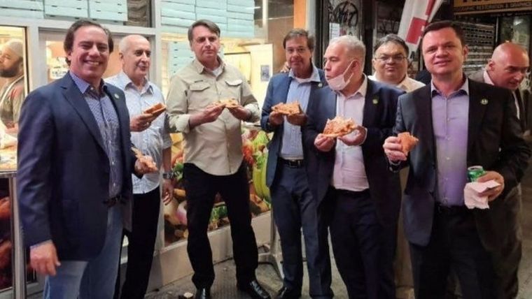 Foto: INSTAGRAM/REUTERS. Pizza y soda en la calle, la cena obligada de Jair Bolsonaro y su delegación en Nueva York.