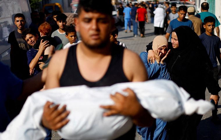 Un hombre lleva el cuerpo de un niño palestino muerto en el ataque Foto: Noticias Argentinas