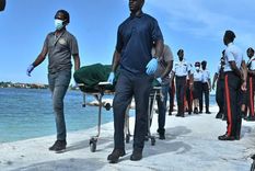 El personal de los servicios funerarios retira el cuerpo de una mujer que murió tras ser atacada por un tiburón toro cerca de Green Cay.  Foto: TORRELL GLINTON