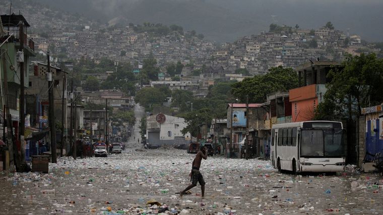 Un hombre camina bajo las lluvias de la tormenta tropical Laura en Puerto Príncipe (Haití).