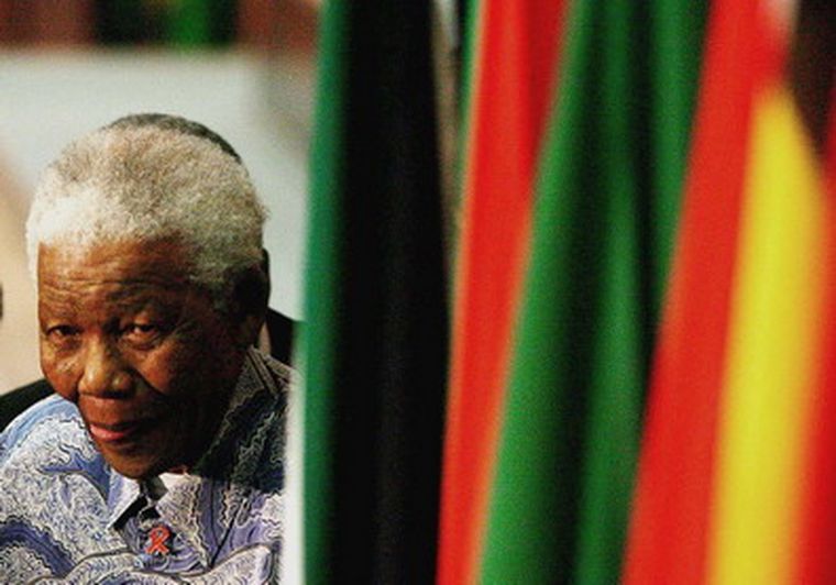 Nelson Mandela junto a la bandera de Sudáfrica. Foto: NA / Archivo