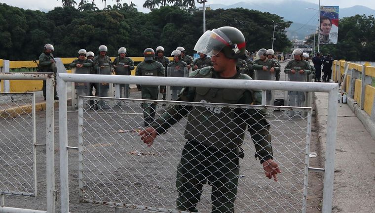 Un integrante de la Guardia Nacional Bolivariana (GNB) instala una valla en la frontera. Foto: EFE