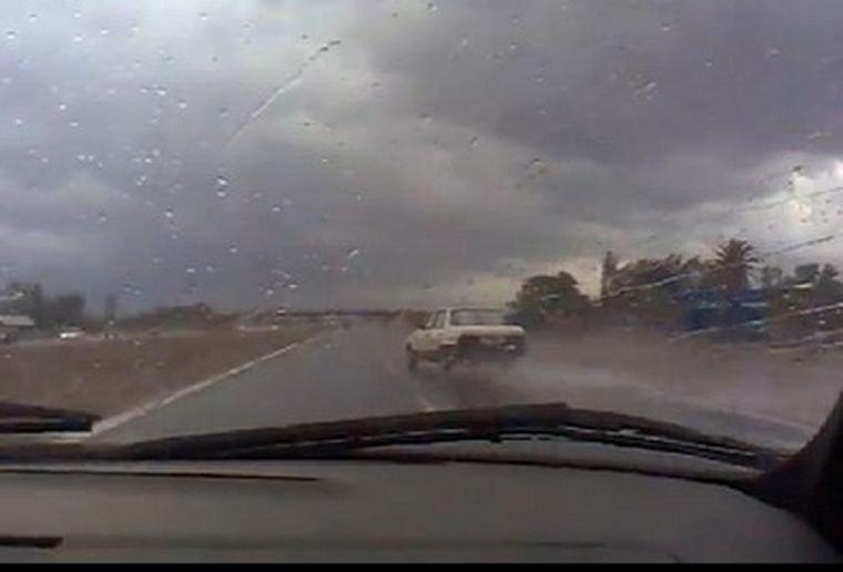 El auto blanco, a punto de derrapar y producir un choque.