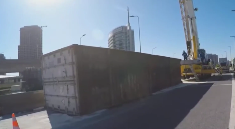 Una grúa trabaja en la zona para remover el container con pollo.