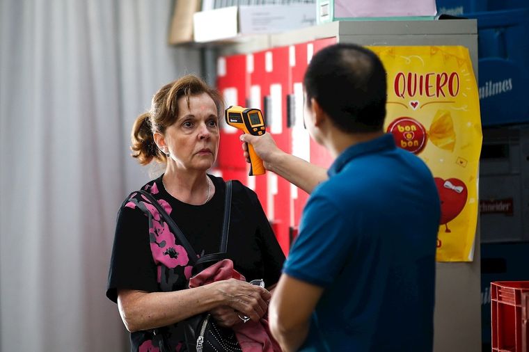 En algunos supermercados controlan la temperatura antes de ingresar.