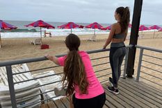 Maca y Ale elongan con una playa vacía frente a ellas.