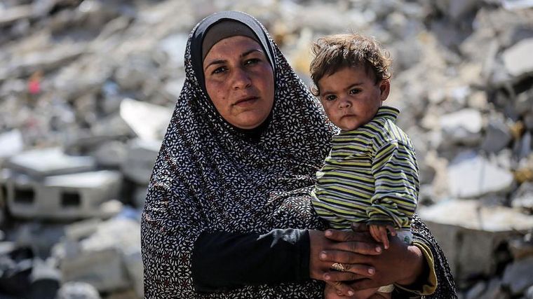 Mujer palestina con su hijo en Gaza.