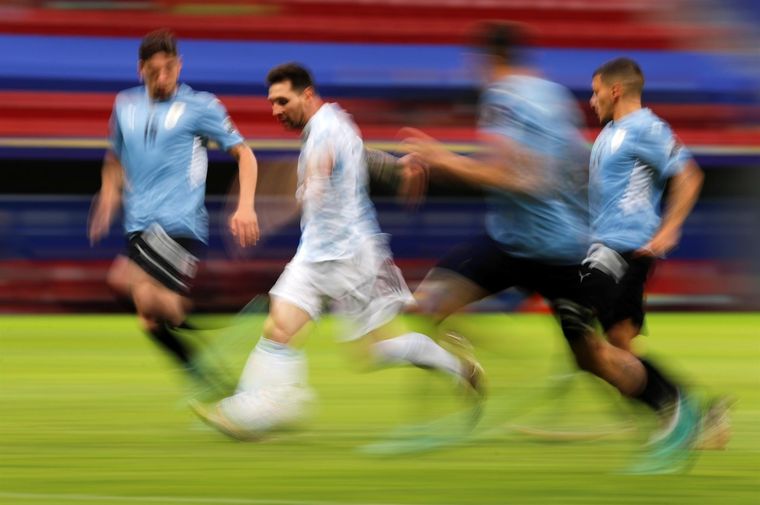 Messi gambeteando uruguayos. Foto: EFE