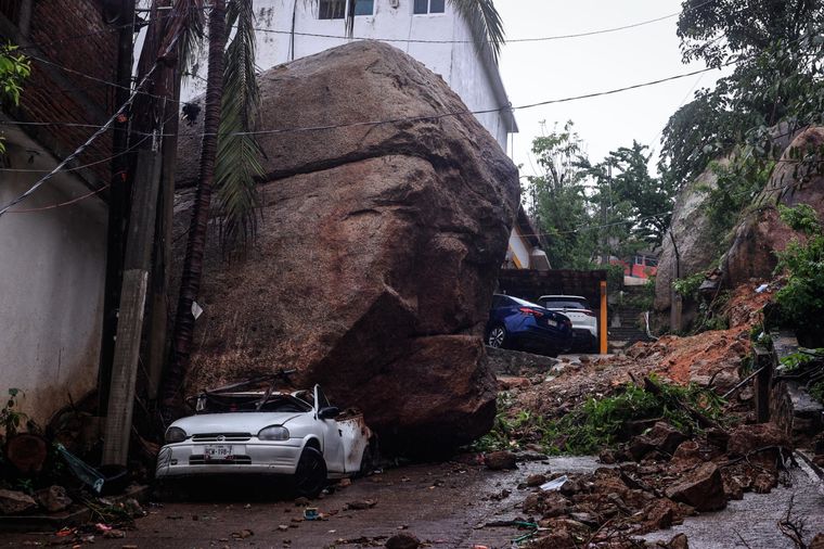 Vehículo bajo una roca provocado, por el paso del huracán John en la parte alta del puerto de Acapulco, en Guerrero (México). Foto: EFE/ David Guzmán