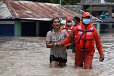 La defensa civil de República Dominicana rescata a una mujer tras las inundaciones causadas por la tormenta Laura.