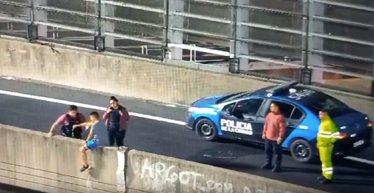 Efectivos de la Policía de la Ciudad intentan convencer al joven para que no salte al vacío Foto: Captura de pantalla
