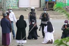 La hermana Ann Rose Nu Tawng arrodillada ante los policías para proteger a los jóvenes manifestantes que buscaron refugio dentro de su clínica. Foto: MYITKYINA NEWS JOURNAL / REUTERS