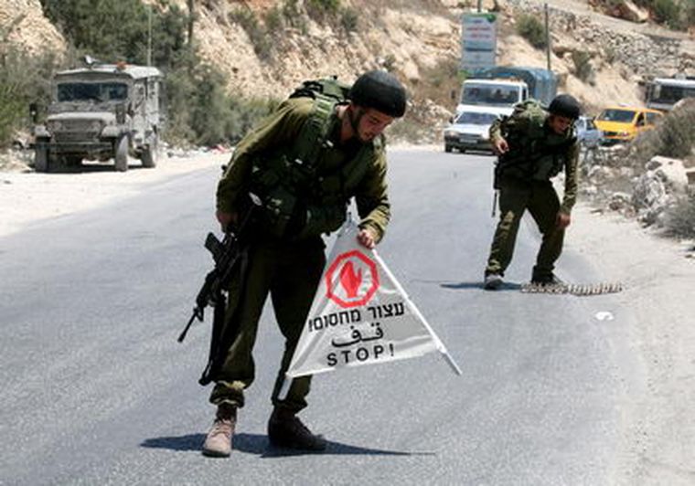 Soldados israelíes colocan señales de stop en un punto de control. Foto: EFE